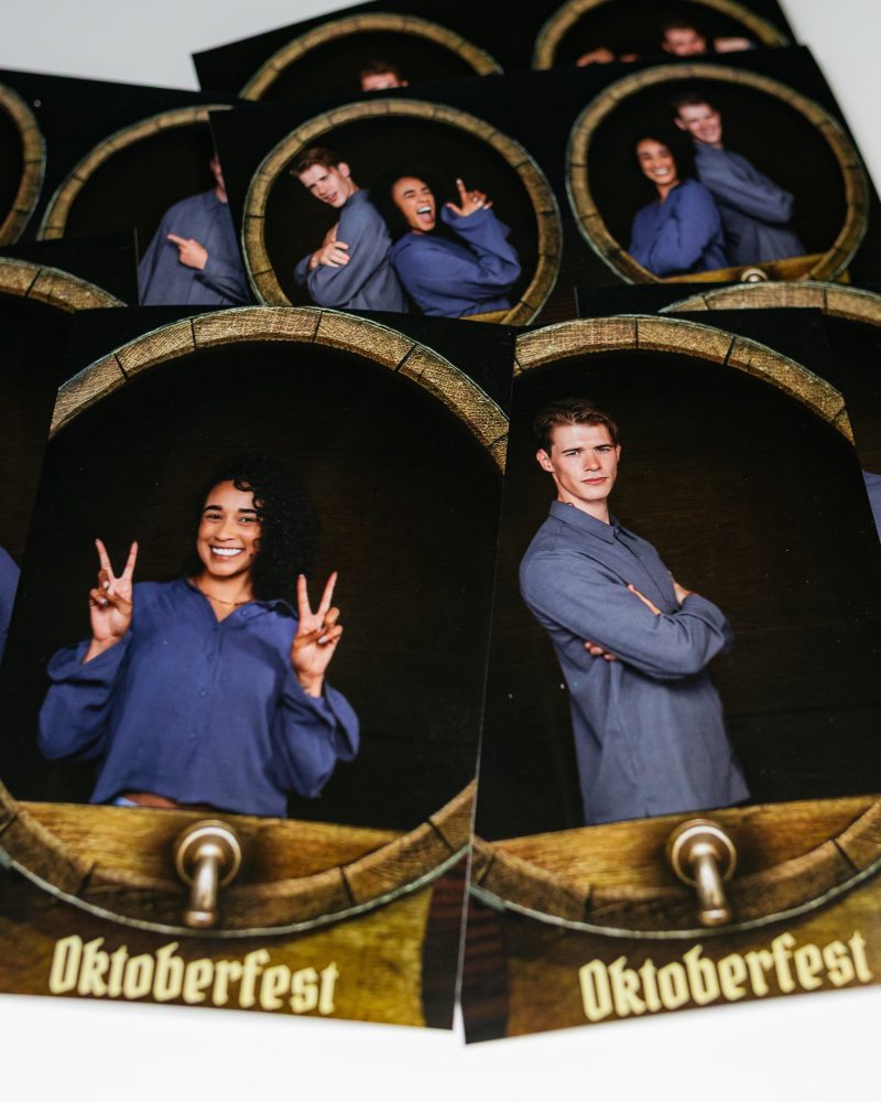 Group posing with fun expressions at Oktoberfest photo booth.