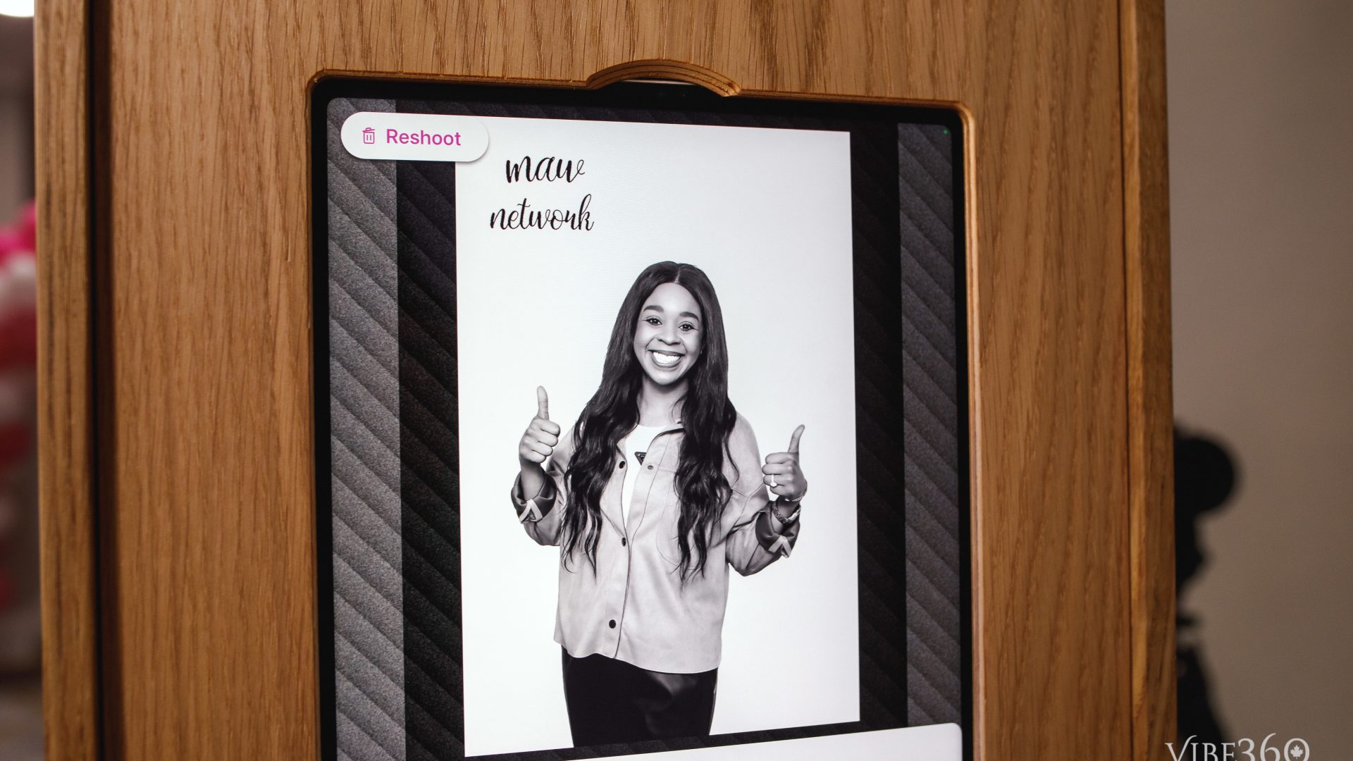 Smiling woman gives thumbs up in a photobooth, displaying 'maw network' logo.