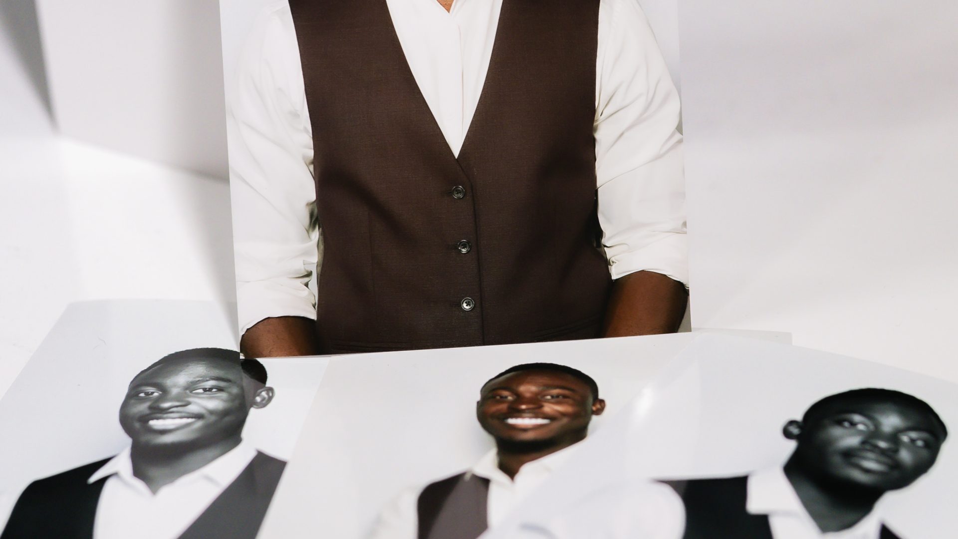 Portrait photos of a smiling man in a vest, displayed on a white surface, showcasing different styles.