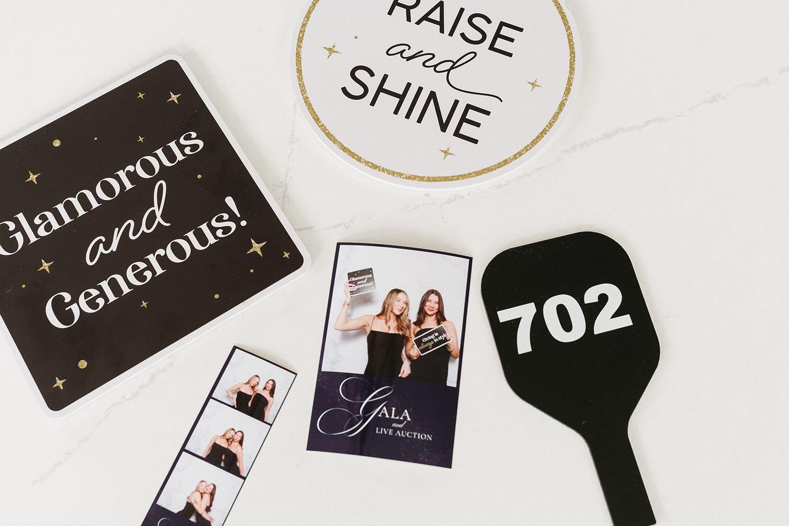 Gala event photo booth items: Glamorous and Generous sign, auction paddle, and pictures from the event.