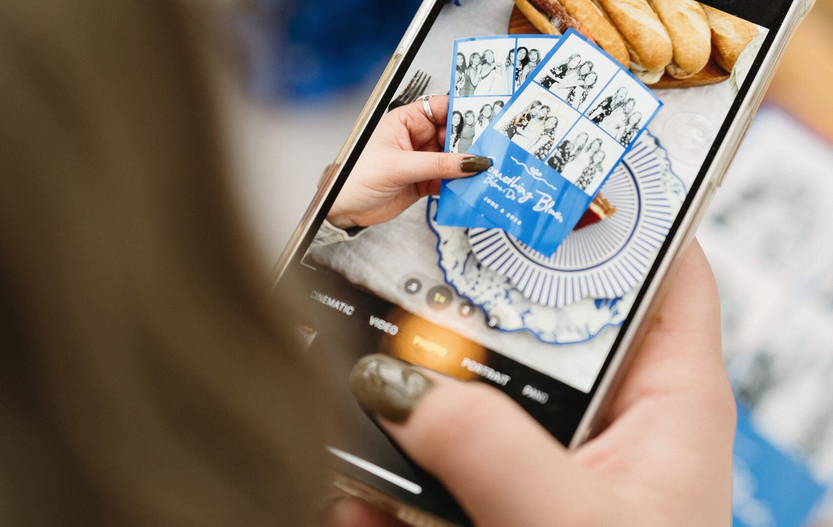 Person photographing event photos and pastries with a smartphone at a celebration.